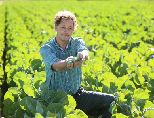 Jan Tuinier Hofman von Stoverland hält frisches Gemüse in die Kamera.