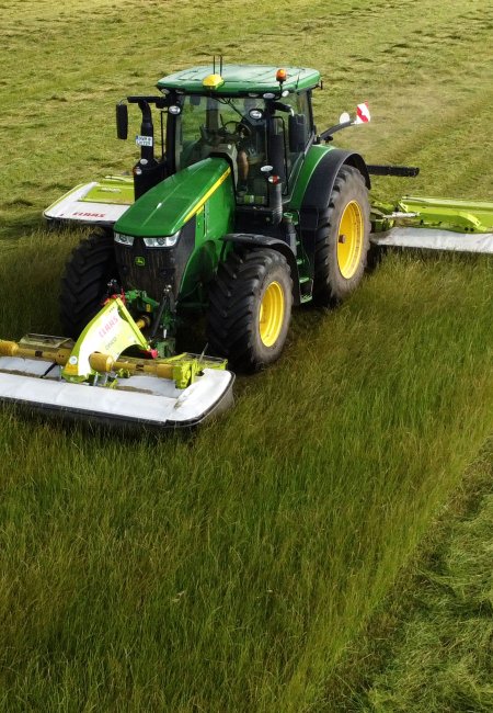 Ein Traktor mäht Gras.